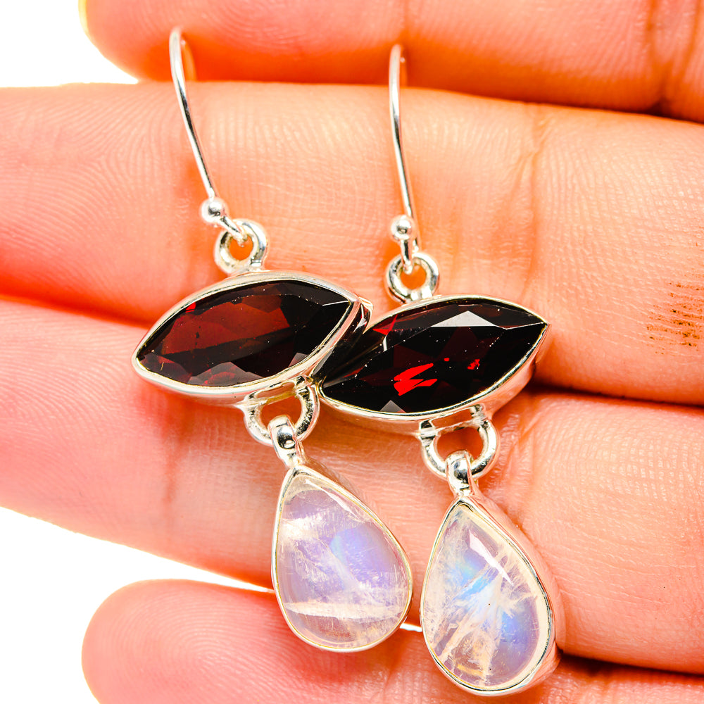 Close-up of sterling silver earrings with red marquise stones and rainbow teardrop drops