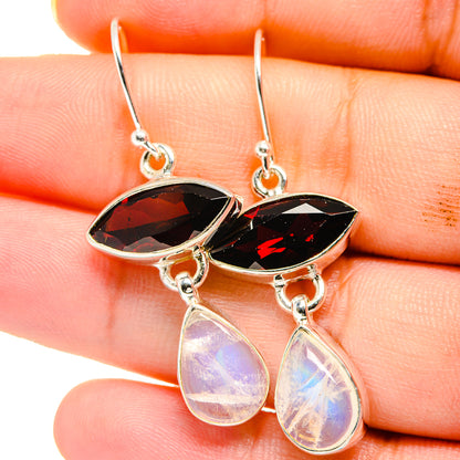 Close-up of sterling silver earrings with red marquise stones and rainbow teardrop drops