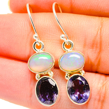 Sterling silver drop earrings with round opal-like stones and oval purple gemstones