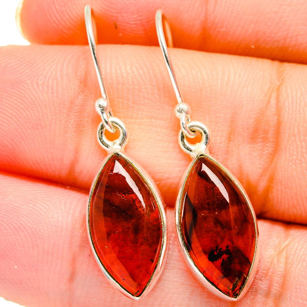 Amber teardrop earrings in silver, close-up of red-orange marbled stones