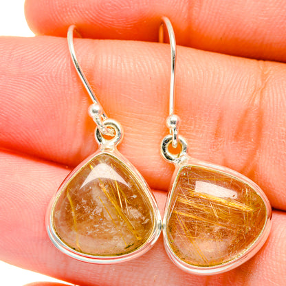 Closeup of teardrop rutilated quartz earrings, amber gold needles in silver setting