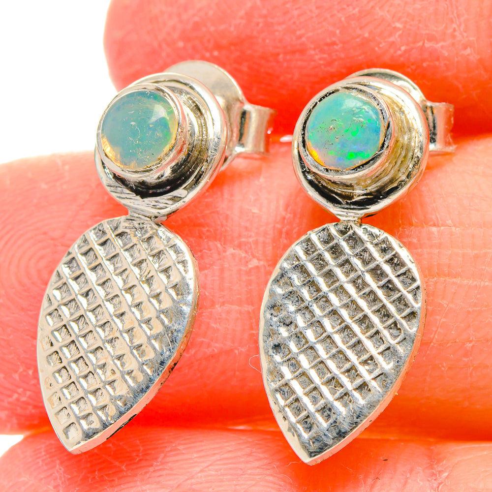 Sterling silver opal stud earrings with green-blue round stone and textured teardrop