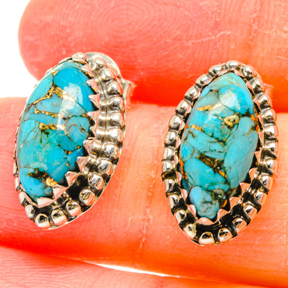 Turquoise cabochon earrings close-up with ornate sterling silver oval frame