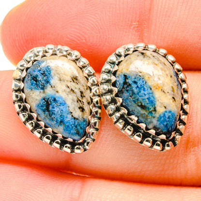 Close-up of oval blue azurite stud earrings with 925 sterling silver scalloped rim