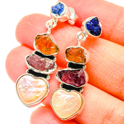 Sterling silver gemstone drop earrings close-up: blue top stones, orange and pink facets, pearls