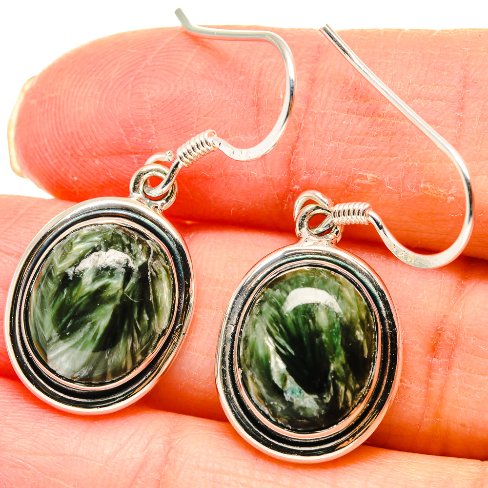 Close-up: oval green stone cabochon earrings with silver bezel and fishhook backs