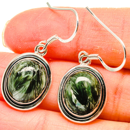 Close-up: oval green stone cabochon earrings with silver bezel and fishhook backs