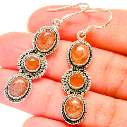 Sterling silver drop earrings with orange sunstone cabochons and beaded settings