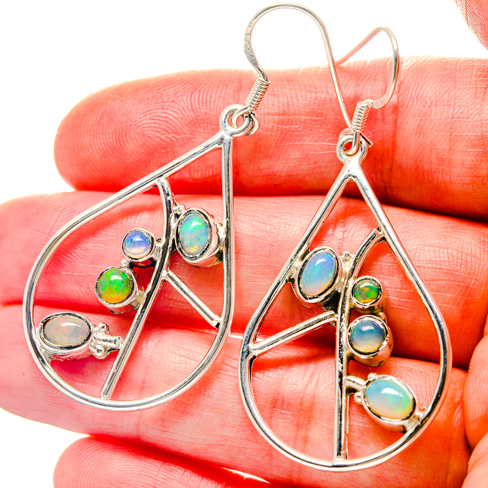 Sterling silver oval opal drop earrings with dangling multicolor stones, close-up
