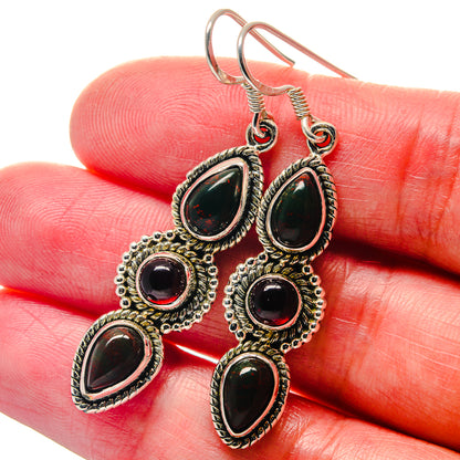 Sterling silver drop earrings with green teardrop stones and red round accents, hook backs