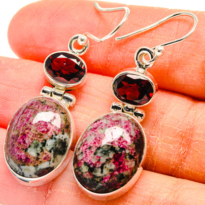 Close-up sterling silver earrings: red round stone above pink speckled teardrop cabochons