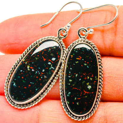 Close-up oval bloodstone cabochon drop earrings with braided border and fishhook