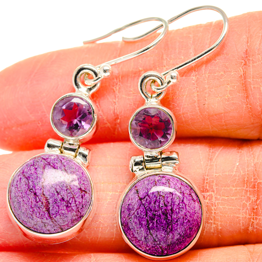 Amethyst drop earrings with purple round stones in silver settings, close-up