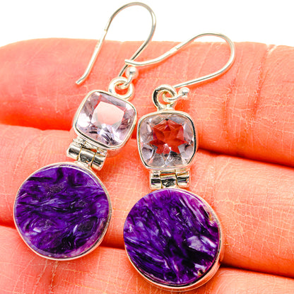 Close-up of purple cabochon and pink faceted drop earrings with silver hooks