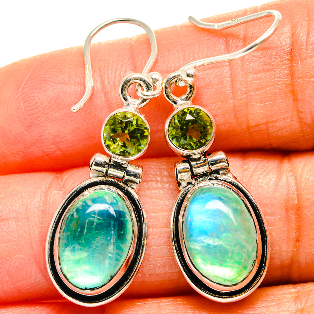 Sterling silver drop earrings with round green peridot tops and oval opal-like moonstones.