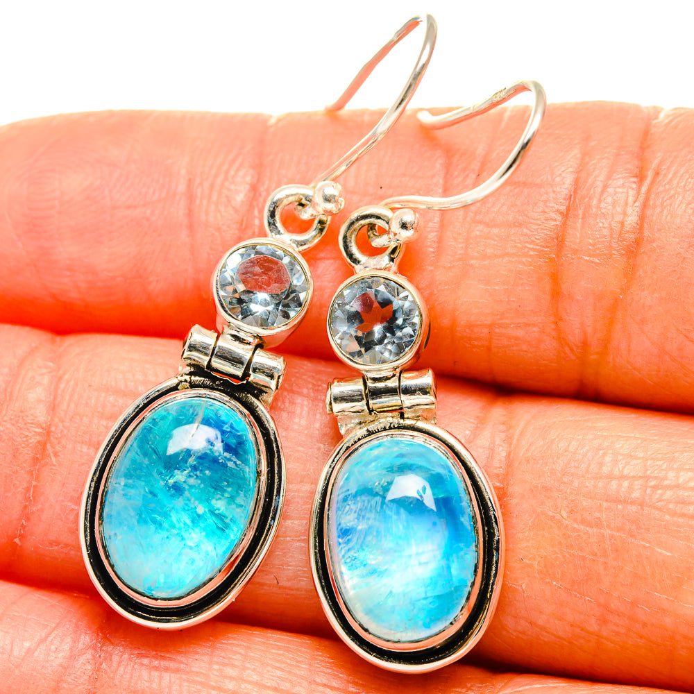 Sterling silver drop earrings with oval blue gemstone and round topaz accents