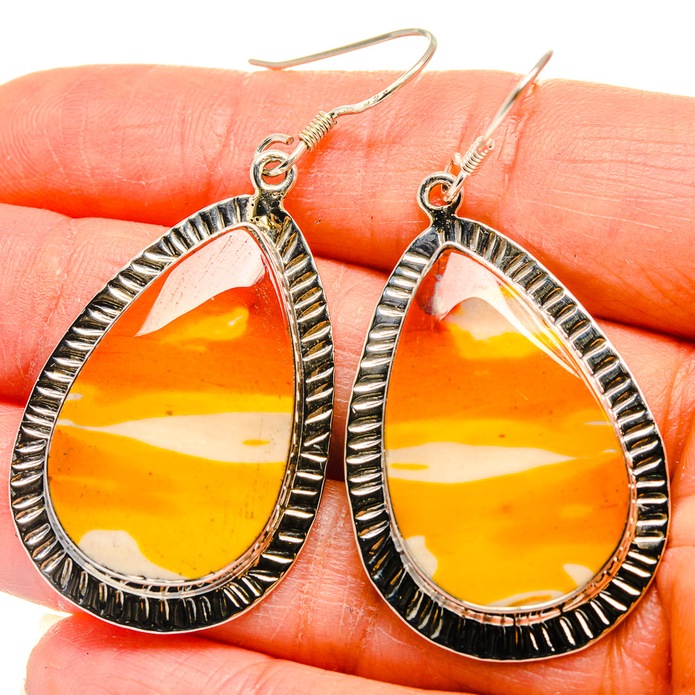 Teardrop stone earrings close-up, orange-yellow with white stripes, silver bezel