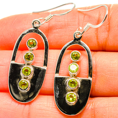 Peridot drop earrings, oval black enamel frame with five green round stones, silver hooks