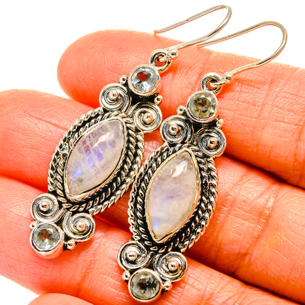 Sterling silver drop earrings with opalescent oval center stone, halo spirals and round gems