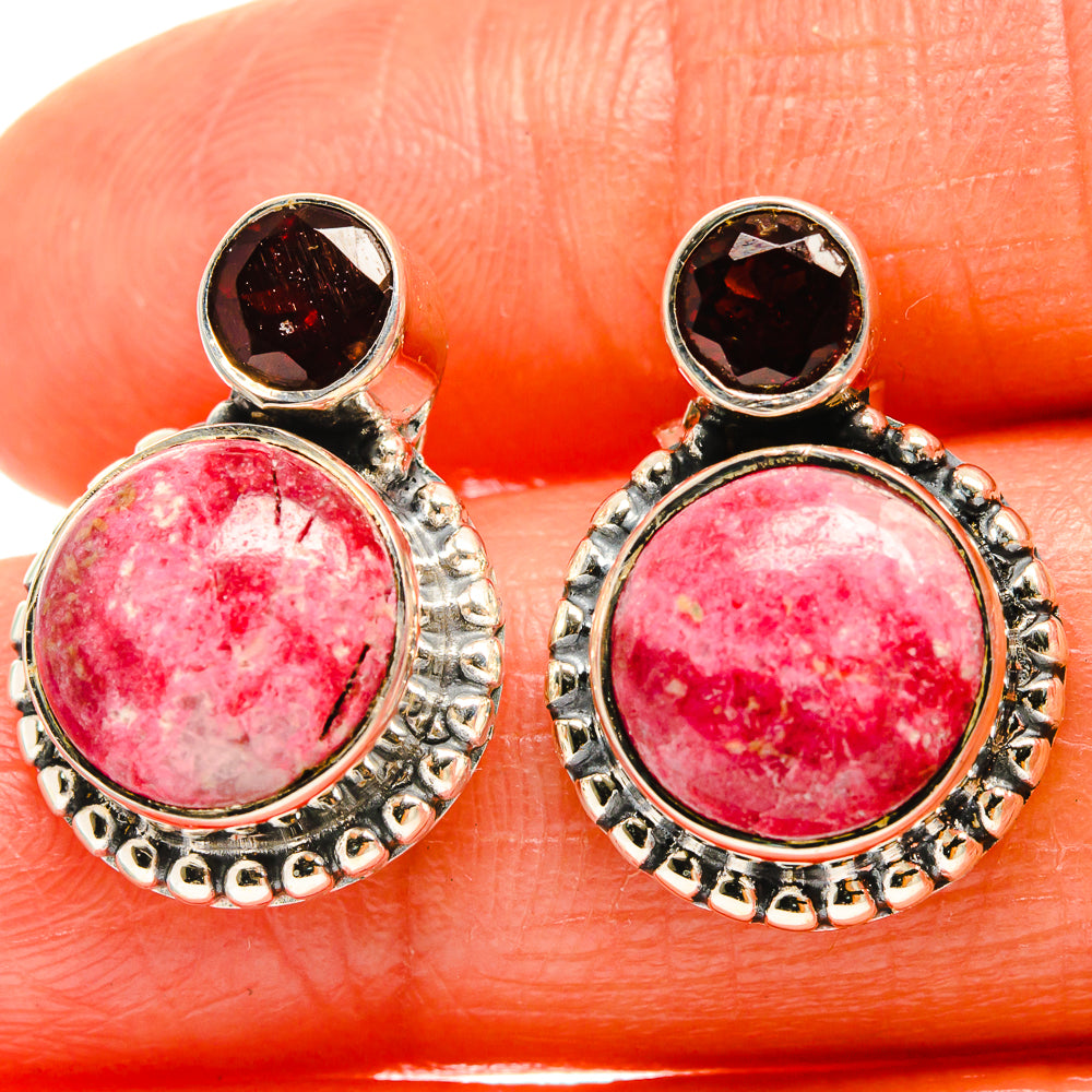 Sterling silver earrings close-up: pink oval center stones with dark garnet caps