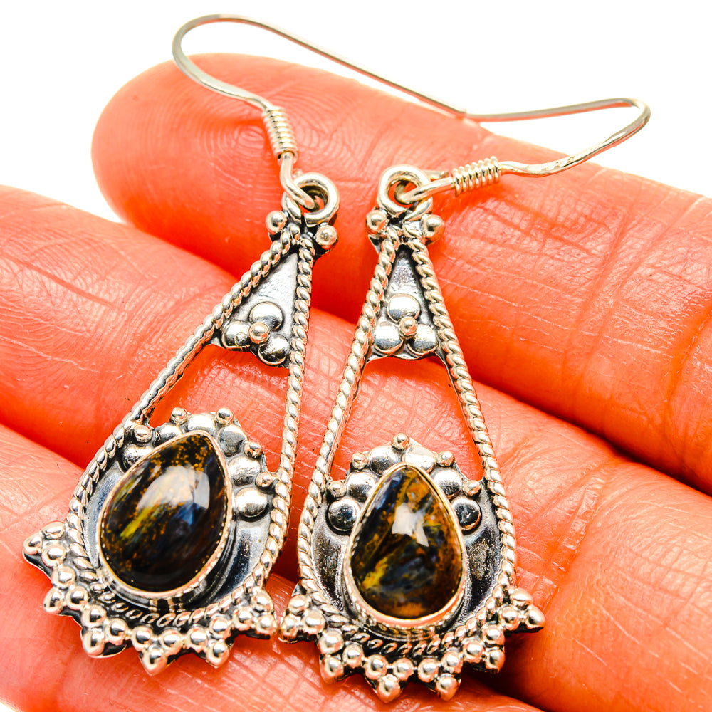 Sterling silver dangle earrings close-up with oval pietersite cabochons in chain frames