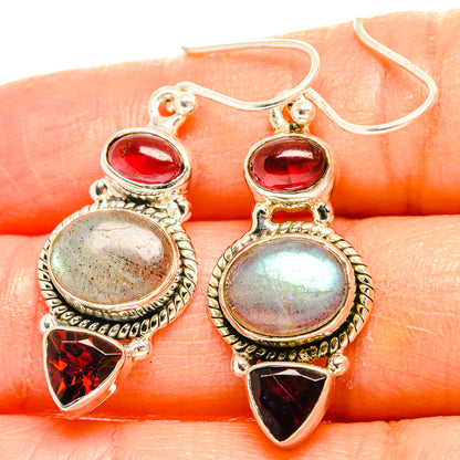 Sterling silver earrings with red stones, iridescent round cabochon, and red teardrop accents