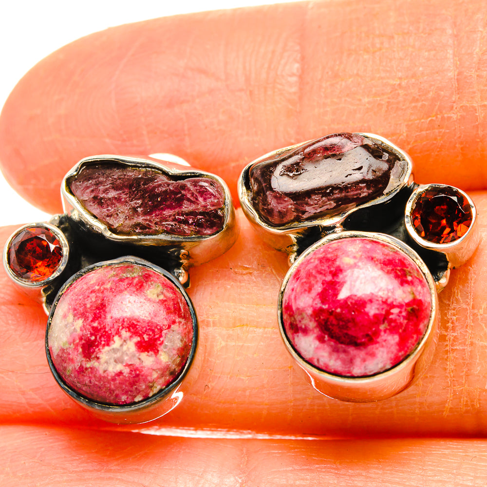 Close-up 925 sterling silver earrings with oval and round red gemstone settings