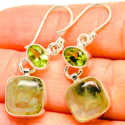 Closeup of sterling silver earrings with round green peridot tops and square prehnite drops