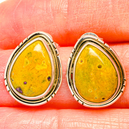 Teardrop gemstone earrings in yellow stone with tiny purple flecks, framed in gold/silver