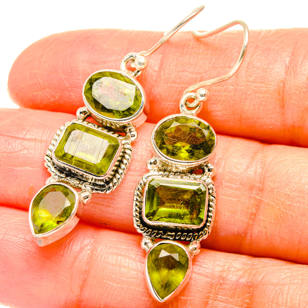 Close-up of peridot green drop earrings in 925 sterling silver with four mixed cut stones