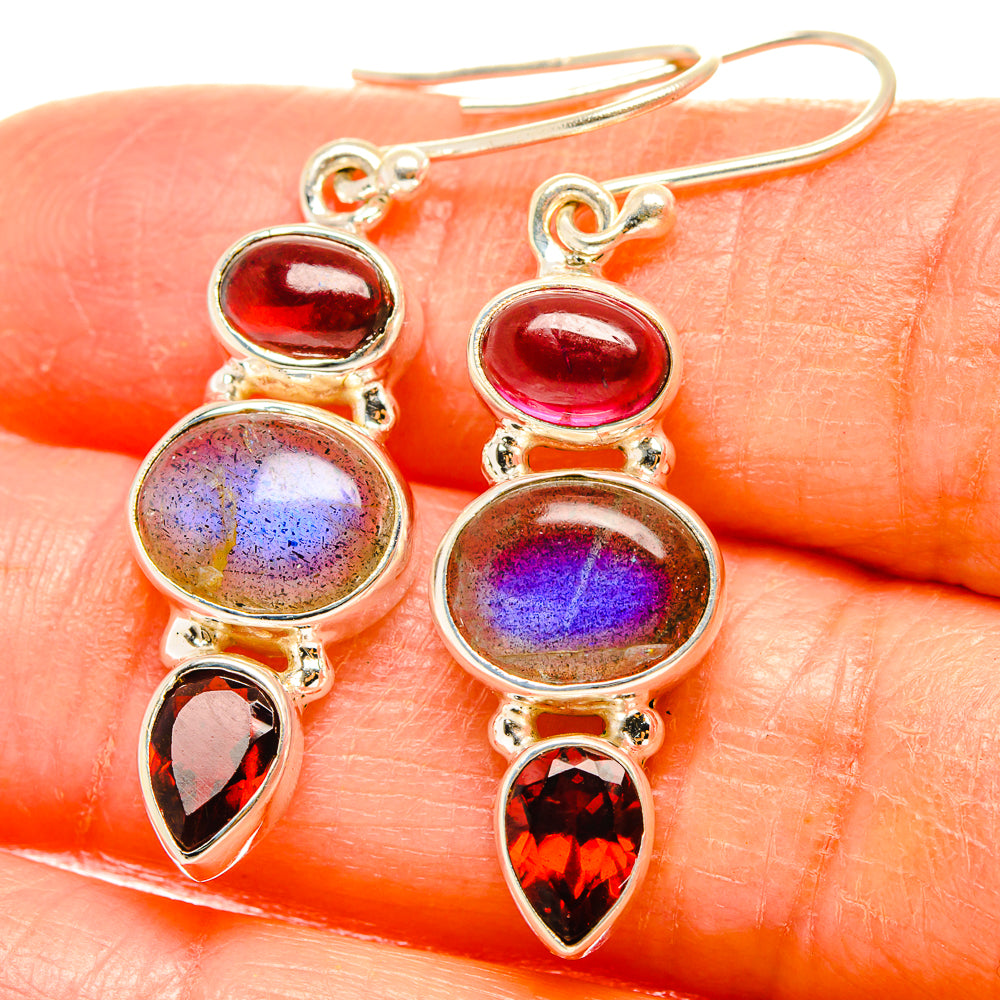 Silver drop earrings with red oval stones, iridescent blue-purple discs, and red teardrop gems