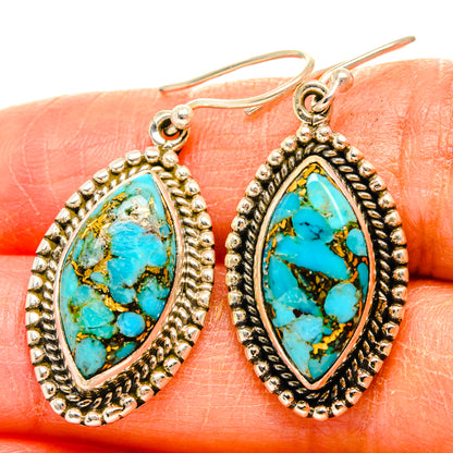 Close-up teardrop turquoise gemstone earrings with bead-edge silver-tone setting and hooks