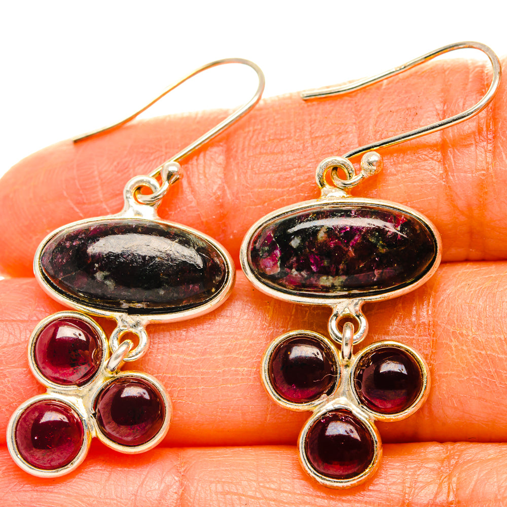 Silver drop earrings with oval black-pink stones and three red round gem accents