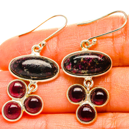 Silver drop earrings with oval black-pink stones and three red round gem accents