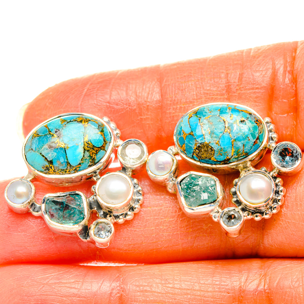 Close-up turquoise oval pearl earrings with silver-tone bezel and blue-green square stones