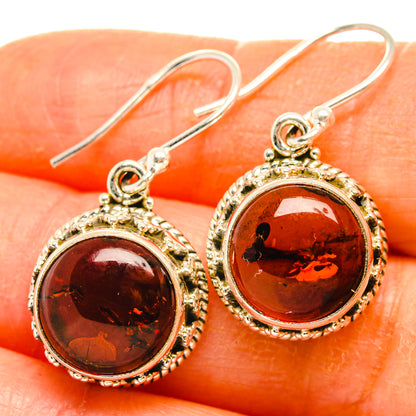 Baltic amber oval drop earrings close-up, ornate 925 sterling silver setting and hooks