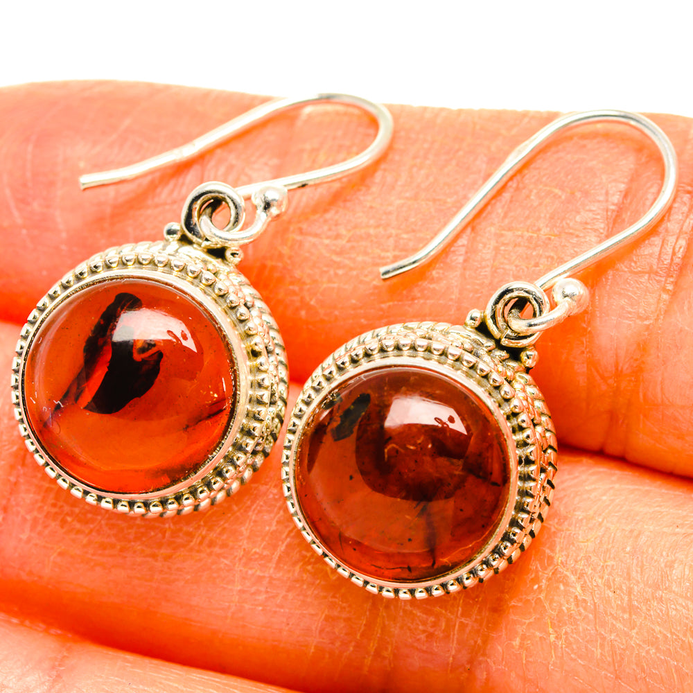 Amber oval earrings in sterling silver beaded frames, close-up with hooks