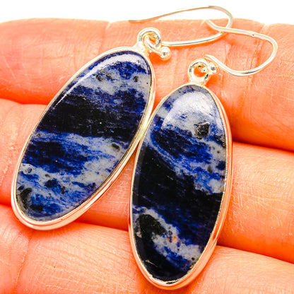 Blue sodalite teardrop drop earrings in 925 sterling silver, close-up on hand