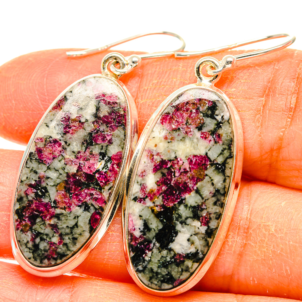 Close-up of oval 925 sterling silver drop earrings with pink and green speckled stone