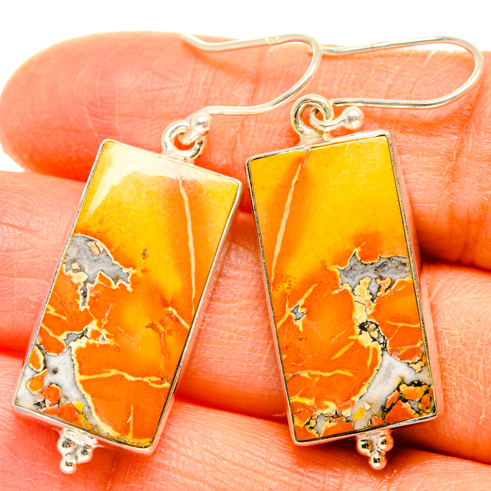 Rectangle jasper drop earrings with orange-yellow stone and sterling silver hooks on hand