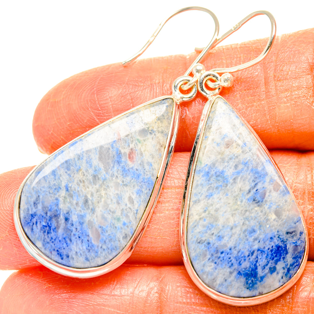 Blue speckled teardrop sodalite earrings on silver-tone hooks, close-up