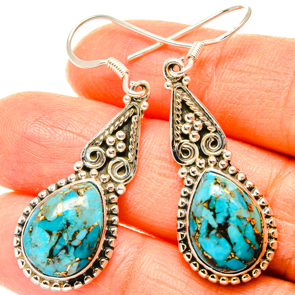 Turquoise teardrop earrings with ornate silver-tone settings and hook backs