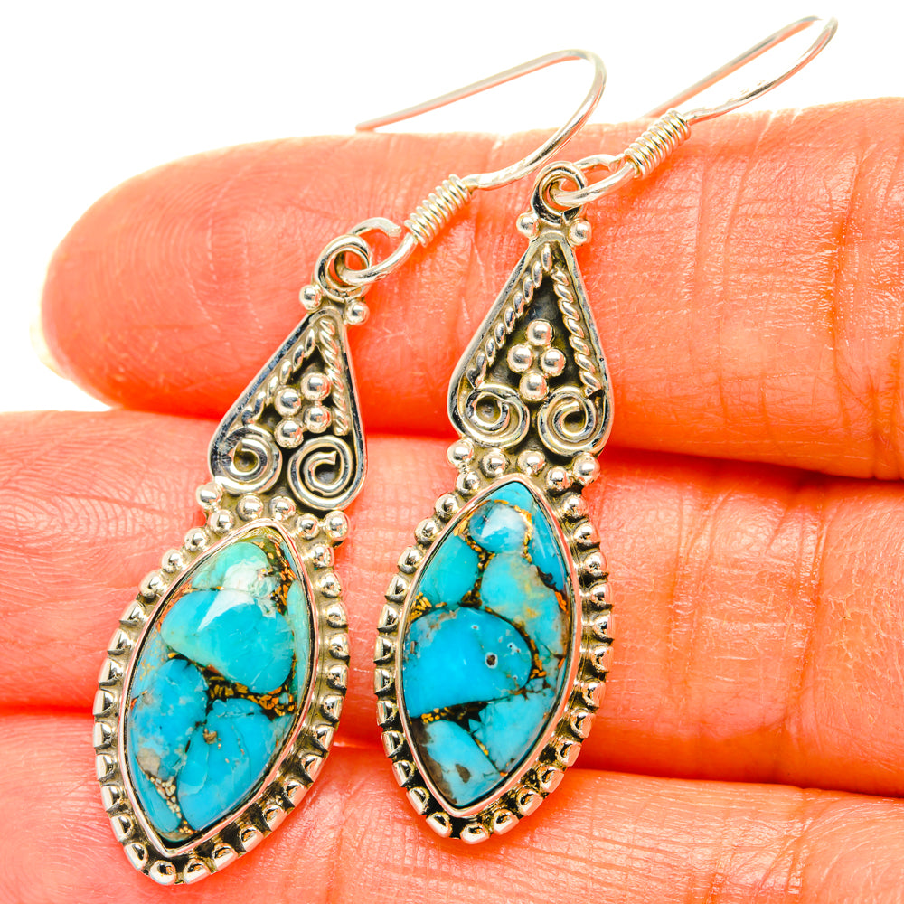 Turquoise teardrop earrings in ornate silver-tone filigree with hook backs