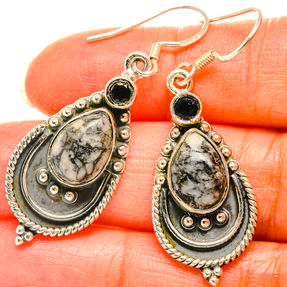 Sterling silver teardrop earrings with black stone and white marbled centerpiece.