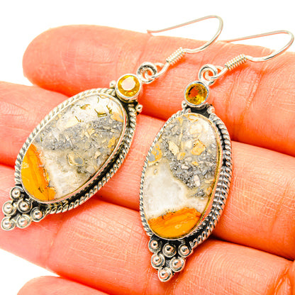 Close-up oval dangle earrings with yellow and orange cabochon, silver filigree, spring hooks