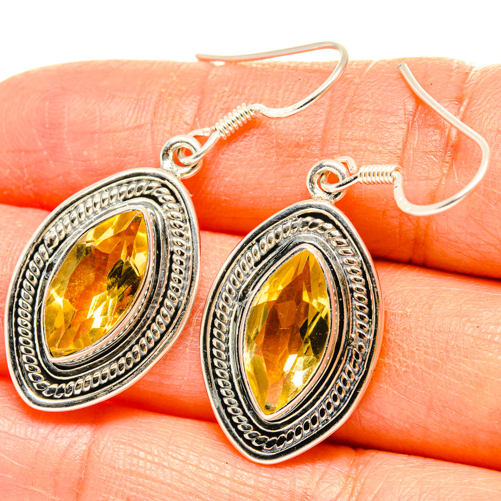 Citrine drop earrings with oval faceted yellow stones and ornate silver frames