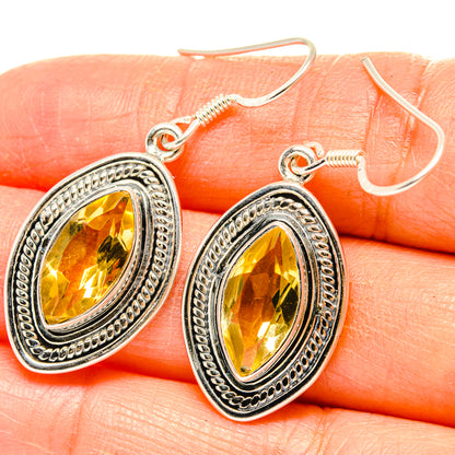 Citrine drop earrings with oval faceted yellow stones and ornate silver frames