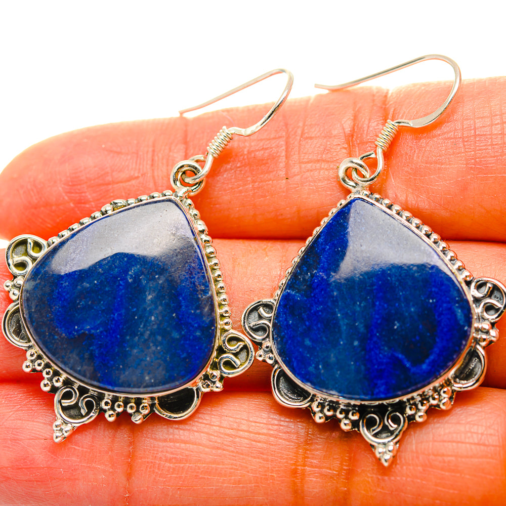 Close-up of blue sodalite teardrop earrings with detailed silver edging and hooks