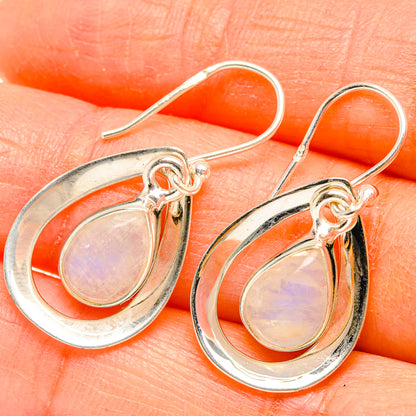 Sterling silver teardrop moonstone earrings on fishhook, showing soft pink iridescence.
