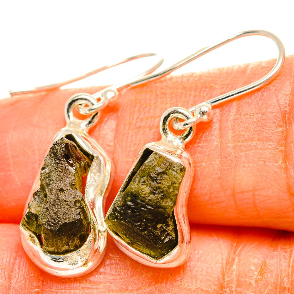 Close-up 925 silver Czech Moldavite hook earrings with textured green stone drops